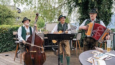 Foto Simeon Baker: Drei Musiker spielen bei der mundART Roas in St. Wolfgang.