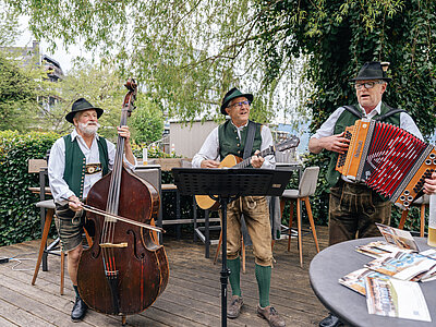 Foto Simeon Baker: Drei Musiker spielen bei der mundART Roas in St. Wolfgang.