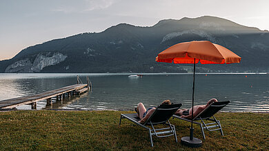 Paar auf Sonnenliegen Strand beim Campingplatz Paradiescamping Wolfgangsee