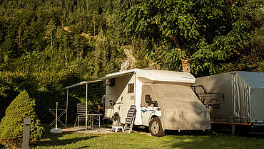 Caravan with seating area at the Paradiescamping Wolfgangsee campsite