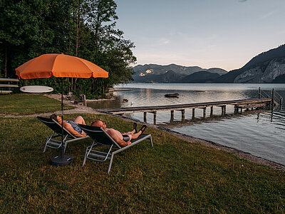 Paar auf Sonnenliegen Strand beim Campingplatz Paradiescamping Wolfgangsee