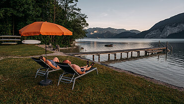 Paar auf Sonnenliegen Strand beim Campingplatz Paradiescamping Wolfgangsee
